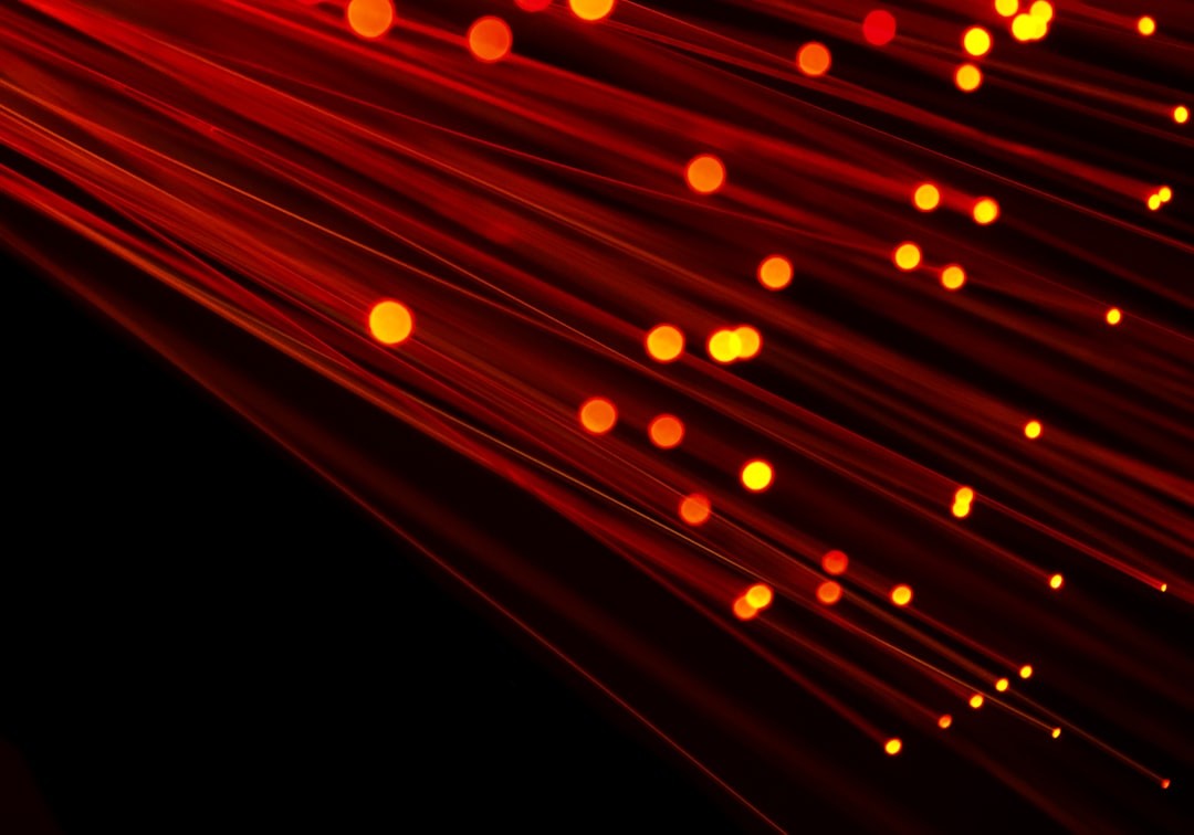 fiber optic light image with red hue on black background. Ideal image to depict broadband, technology, speed and cable infrastructure.